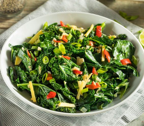 A bowl of collard greens, in a white bowl.