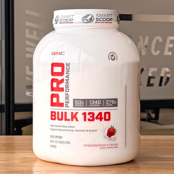 White tub of Pro Performance Bulk 1340 protein powder on wooden table..