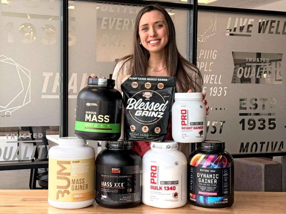 Mary Milstead with tubs of protein powders, her best mass gainer picks.