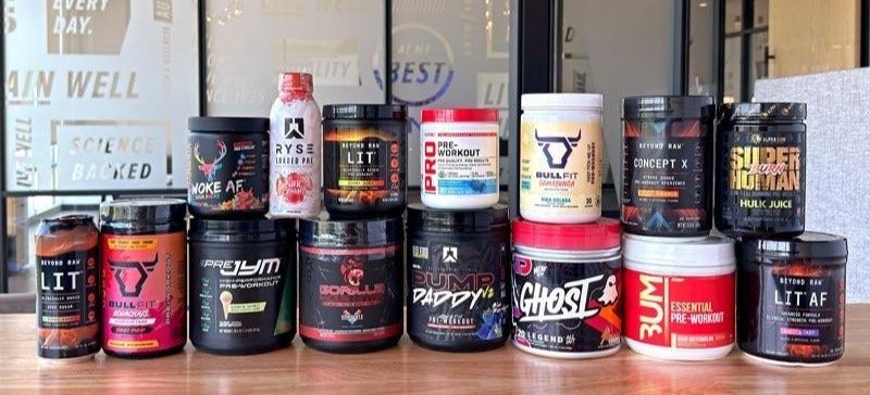 Tubs of the best pre-workouts, stacked on a table.