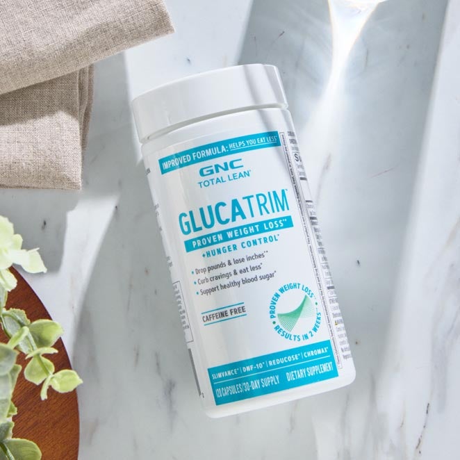 White and teal bottle of GlucaTrim, on marble counter.