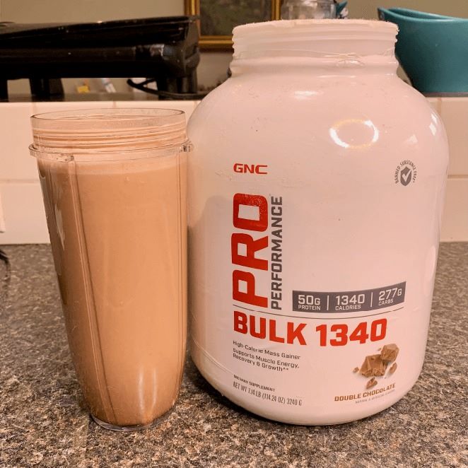 ProPerformance Bulk 1340 protein powder shak next to white tub.
