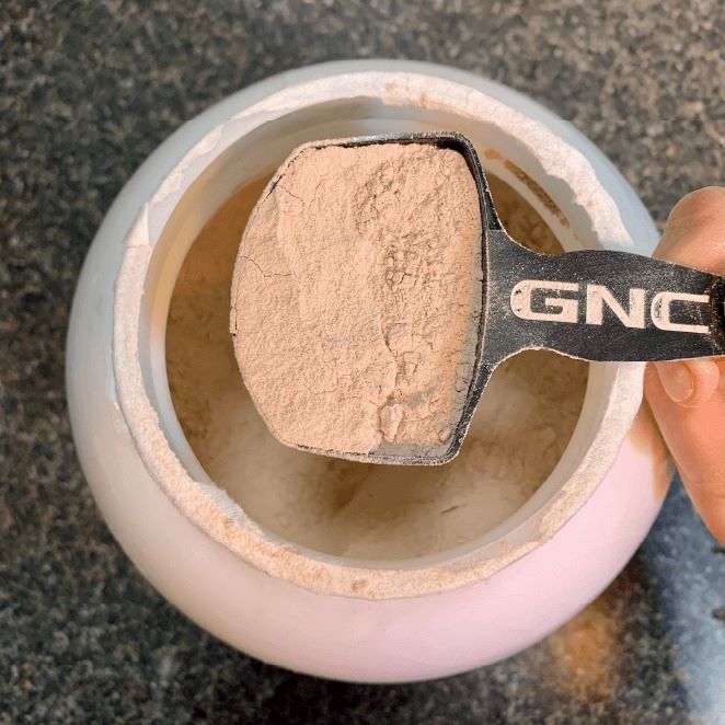 Scoop of chocolate protein powder mass gainer.