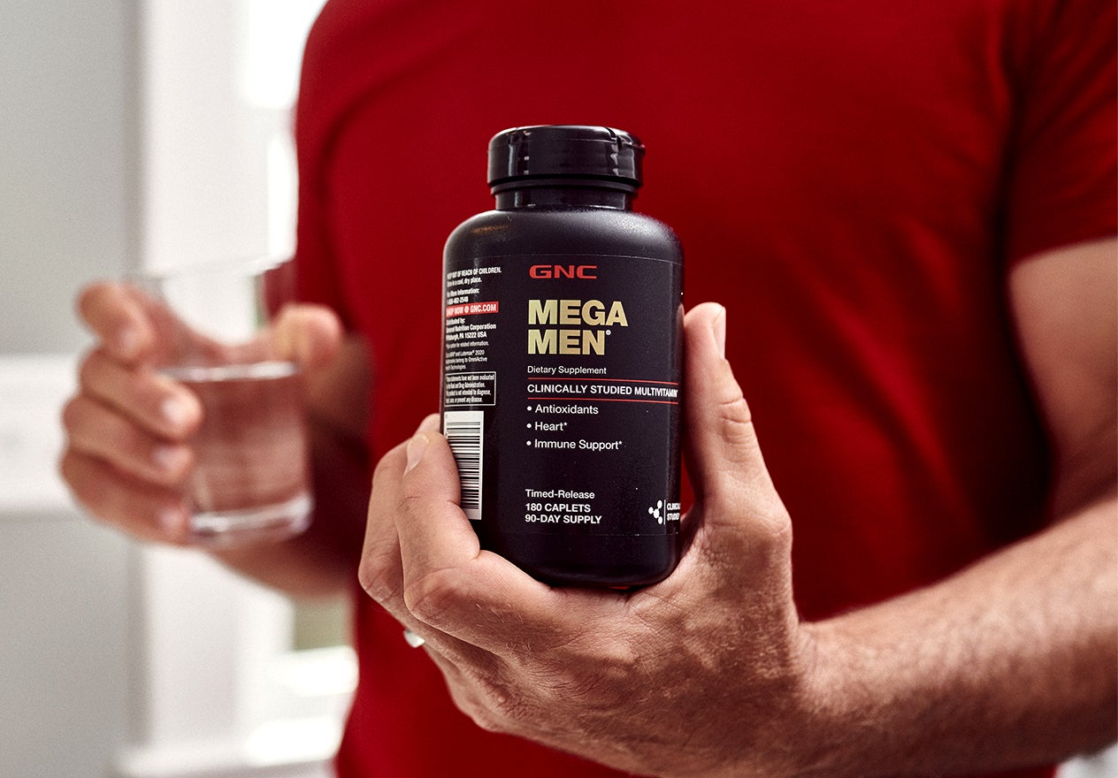 Man holding GNC Mega Men Multivitamins - Best Male Enhancement Supplement At Gnc
